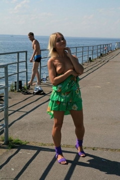 Улыбчивая блондинка на набережной сняла с себя зеленое платье 2 фото